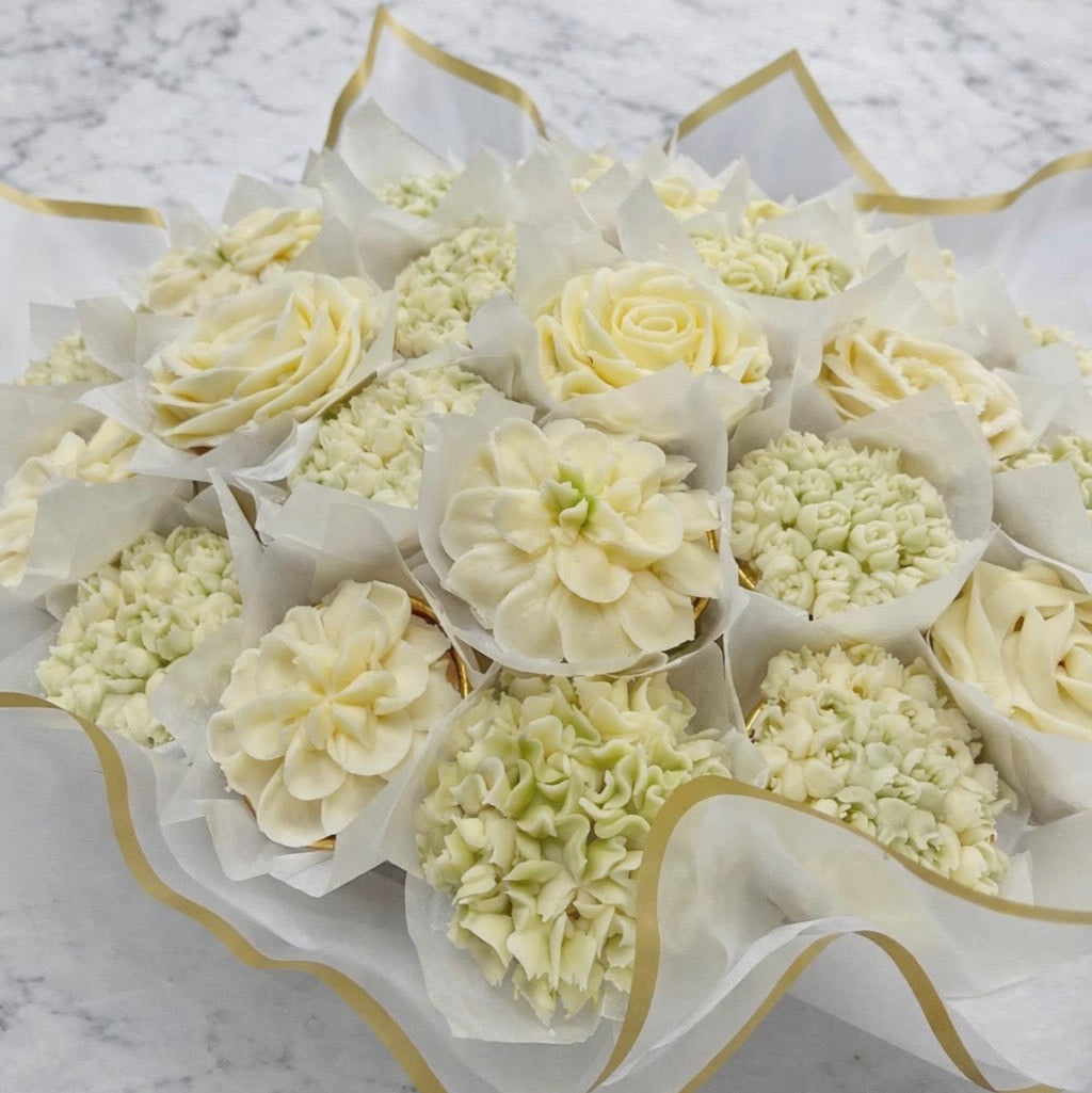Cupcake Bouquet of white cupcakes with gold accents on a marble surface